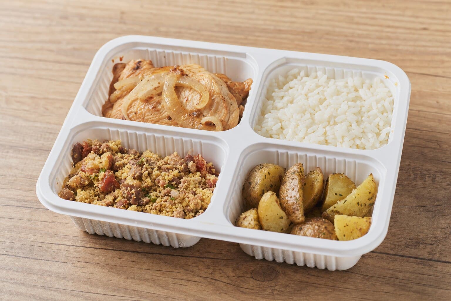 Refeição em embalagem individual de quatro divisórias: frango grelhado acebolado, arroz, feijão tropeiro e batata rústica